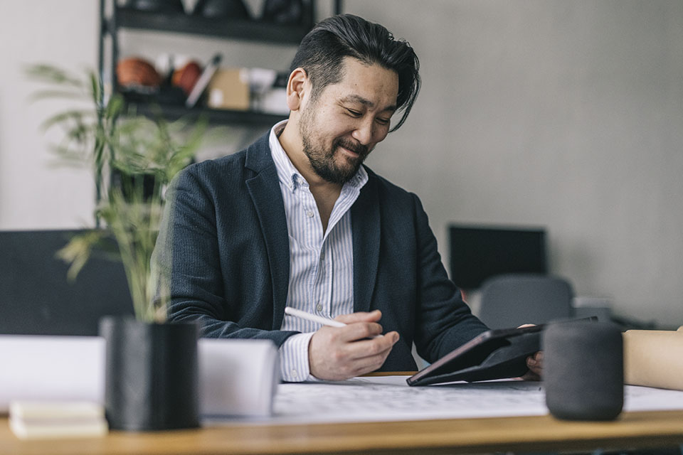 Business professional considering what his next career move will be while reviewing research on a tablet.