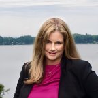 Kristin Haag in purple top and black blazer, looks at the camera.