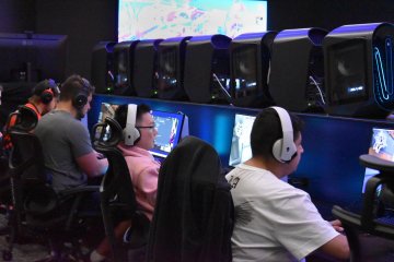 Students in the eSports program, seated in chairs at computer screens in the all-new eSports auditorium.