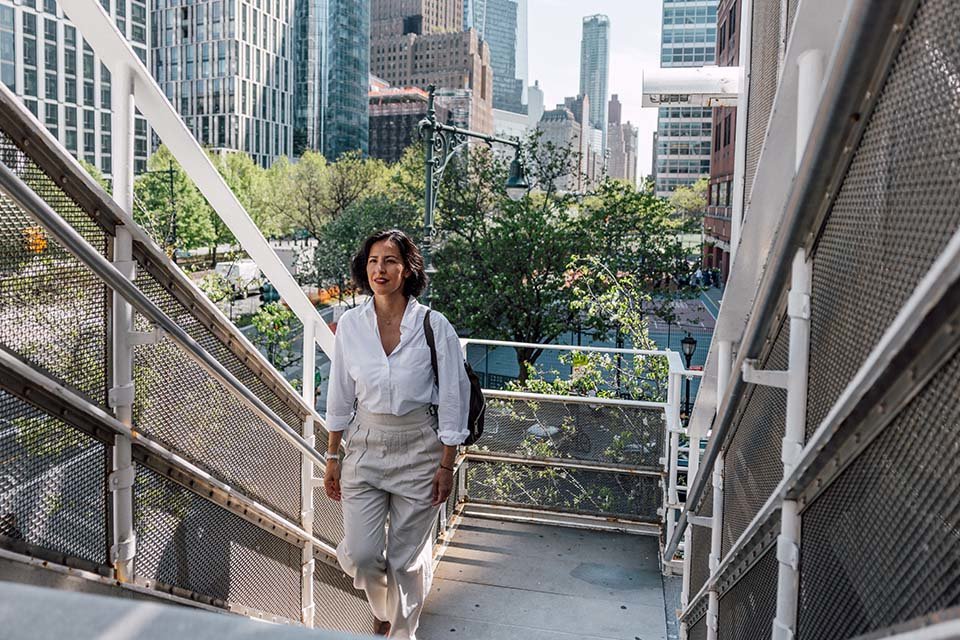 Business woman walking up stairs outside in a city.