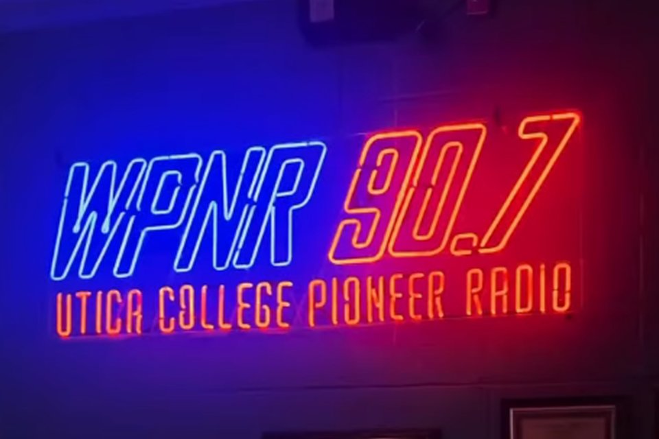 Blue and Orange Neon sign reading WPNR 90.7 Utica College Pioneer Radio